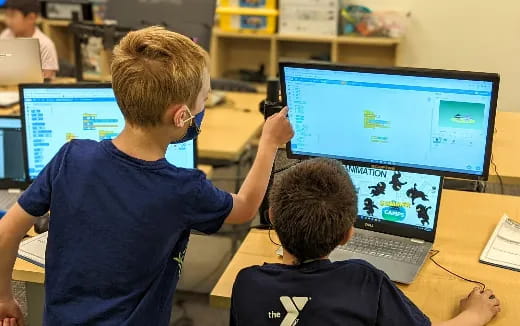 a couple of boys using computers