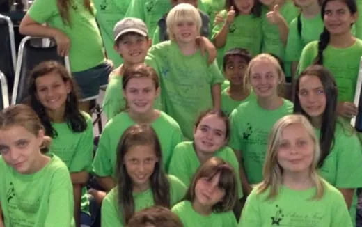 a group of children in green shirts