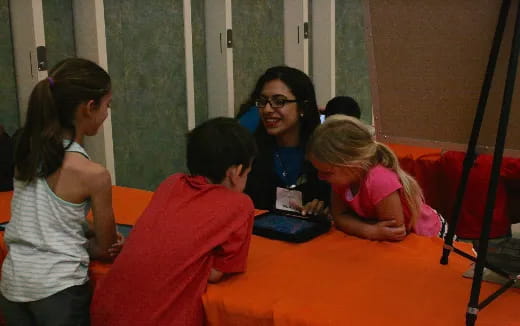 a group of children sitting around a table