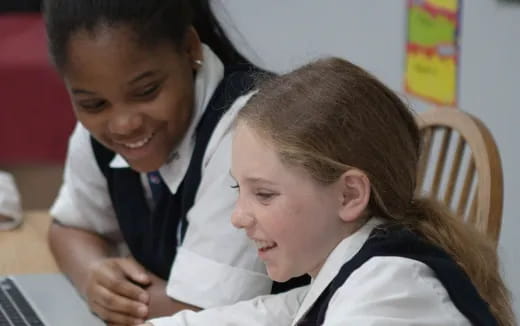 a woman and a girl looking at a computer