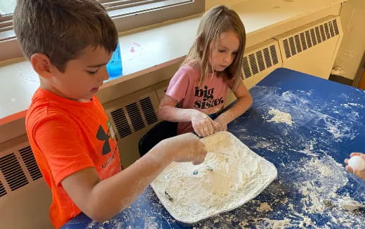 a boy and girl playing with sand