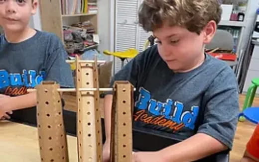 a couple of boys playing with a wooden structure