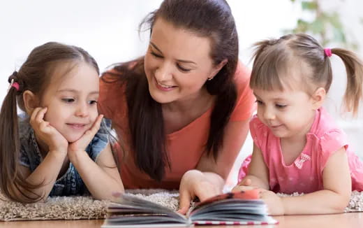 a person and two children looking at a tablet