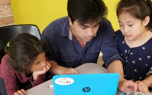 a group of children looking at a tablet