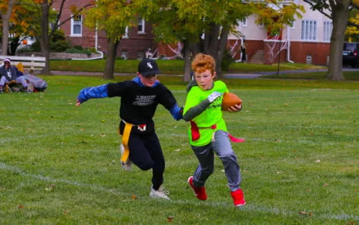 a couple of kids playing with a ball on a field