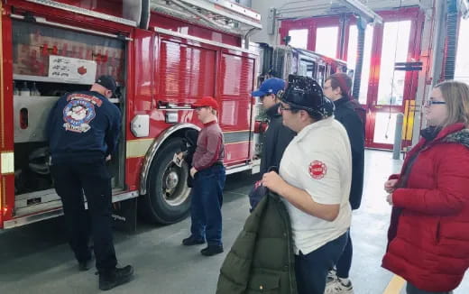 a group of people standing next to a fire truck