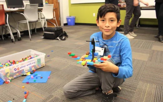 a boy sitting on the floor holding a toy