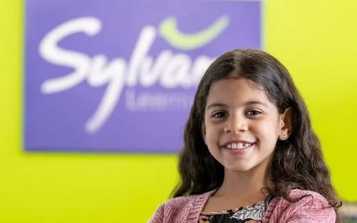 a girl smiling in front of a sign