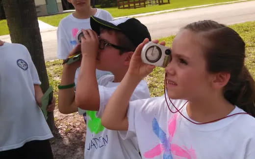 a group of kids drinking from a cup