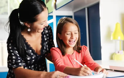 a woman and a girl looking at a paper