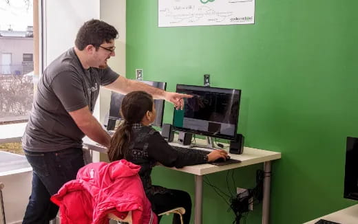 a man showing a woman something on the computer