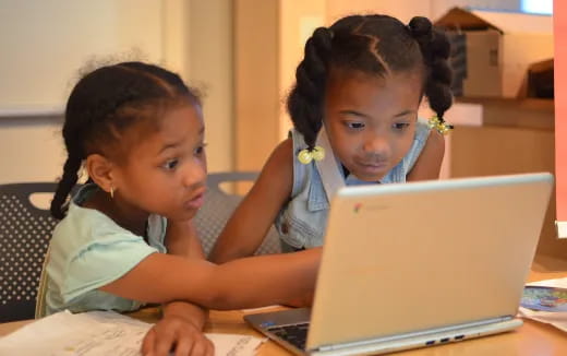 a few young girls using a laptop
