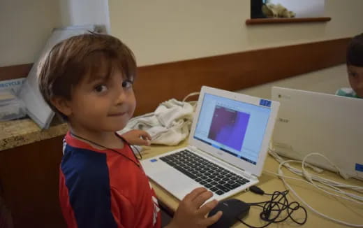 a young boy using a laptop