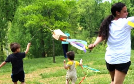 a person and kids playing with a kite