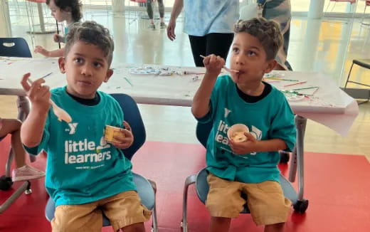 a couple of boys sitting at a table eating food