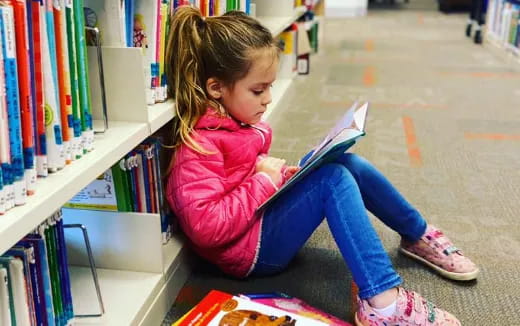 a young girl reading a book