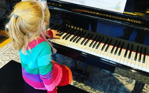 a little girl playing a piano