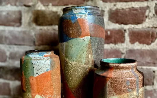 a few vases sit on a shelf