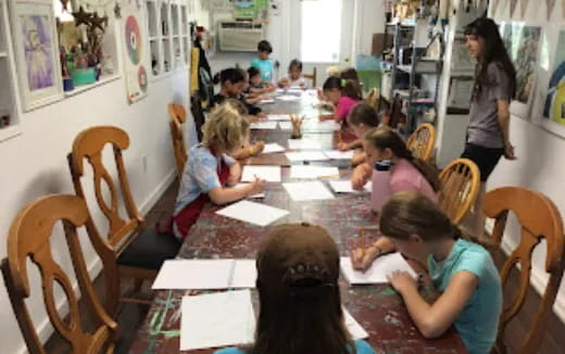 a group of children sitting at a table in a room