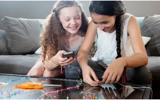 a couple of women looking at a cell phone