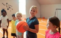 a group of children playing basketball