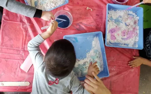 a child drawing on a red table