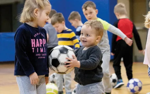 a group of children playing with a football ball
