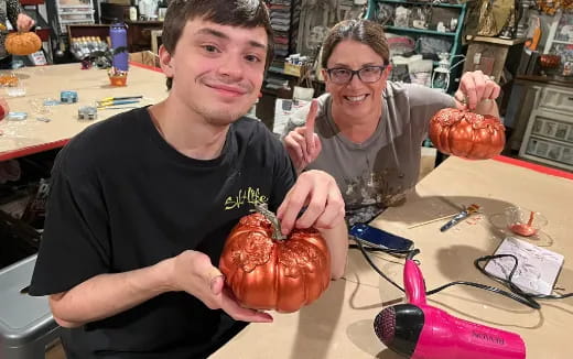 a couple of men holding a pumpkin