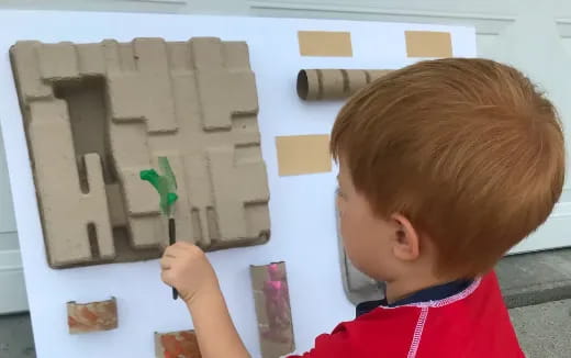 a child painting on a white board