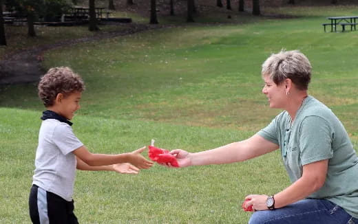 a person and a child playing with a toy in a park