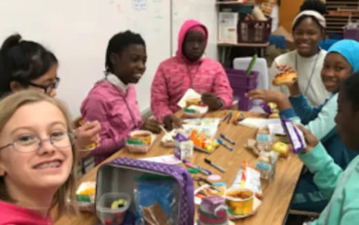 a group of people sitting around a table with food