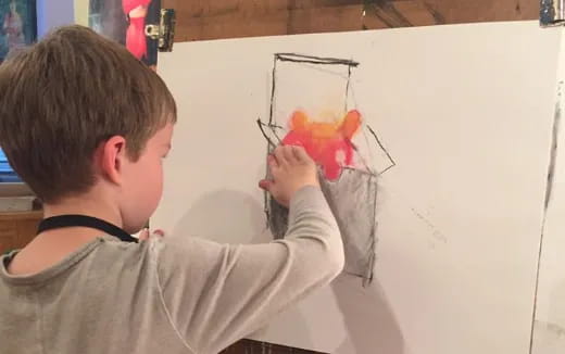 a boy drawing on a white board