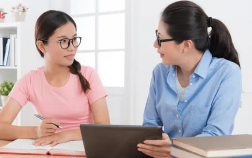 a woman and a woman looking at a laptop