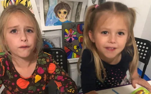 a couple of girls sitting at a table