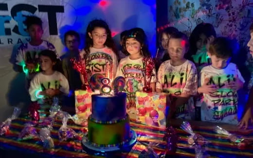 a group of children around a cake