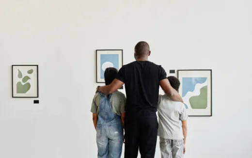 a group of people looking at art on a wall