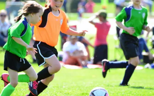 girls playing football on a field