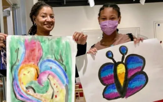a couple of girls holding up a drawing