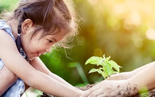 a young girl looking at a plant