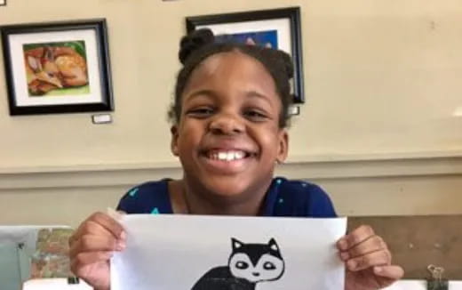 a girl smiling and holding a sign