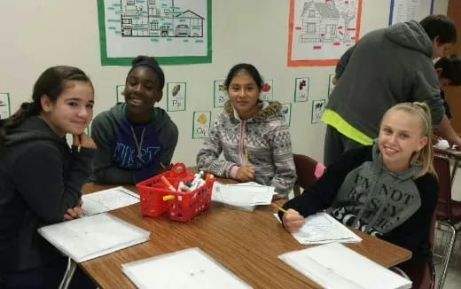 a group of people sitting at a table with a toy car