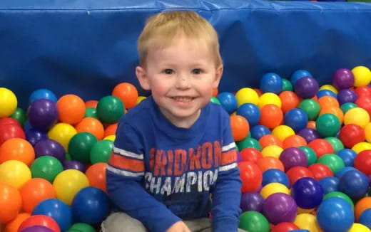 a baby sitting in a ball pit