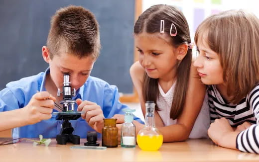a group of children looking at a microscope