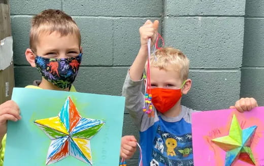 a couple of young boys holding kites