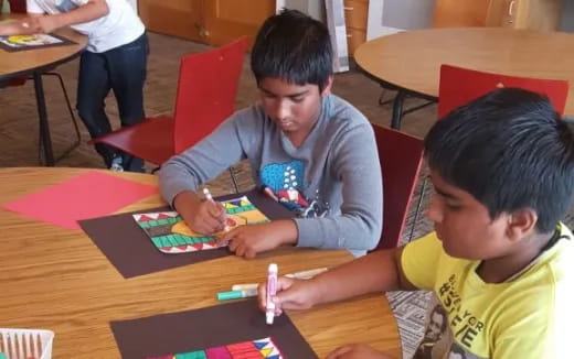 a few boys sitting at a table