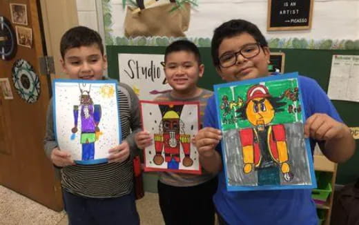 a group of boys holding up artwork