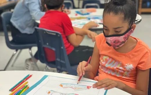 a young boy drawing on paper