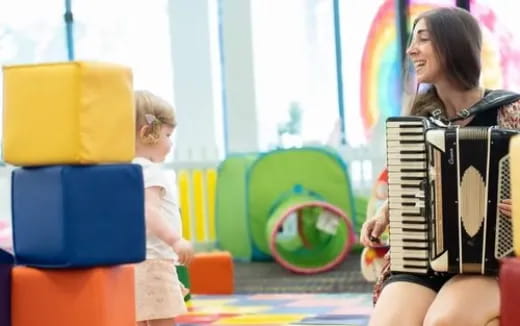 a woman and a child playing an accordion