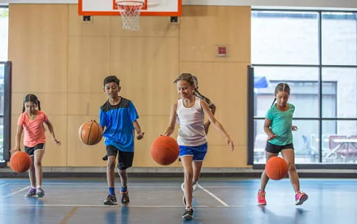 a group of kids playing basketball