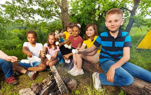 a group of children sitting around a fire